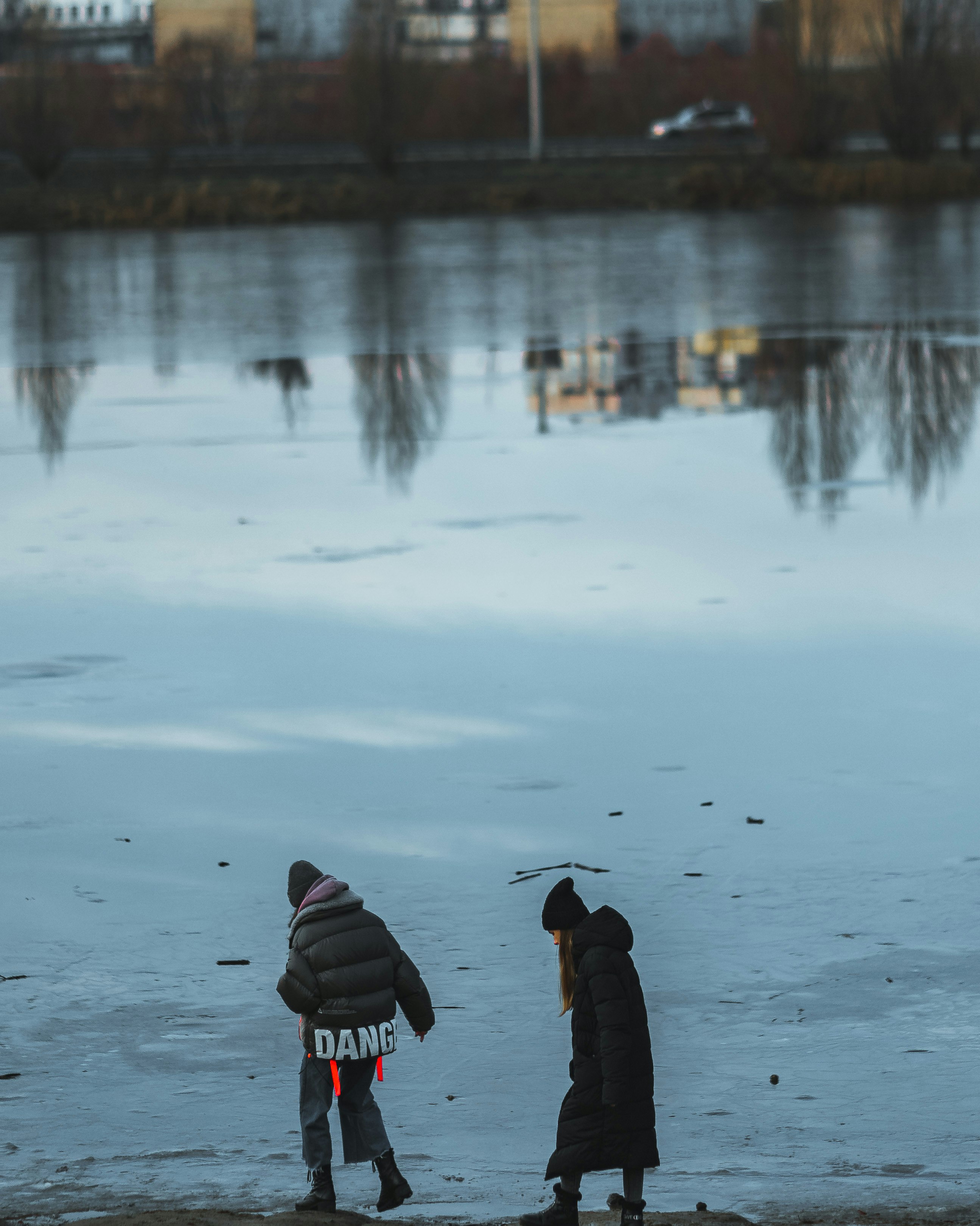 person in black jacket and red and white striped knit cap standing on snow covered ground